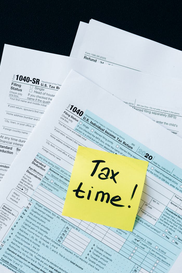 services-01 IRS 1040 tax forms with handwritten Tax Time! note for filing reminder.