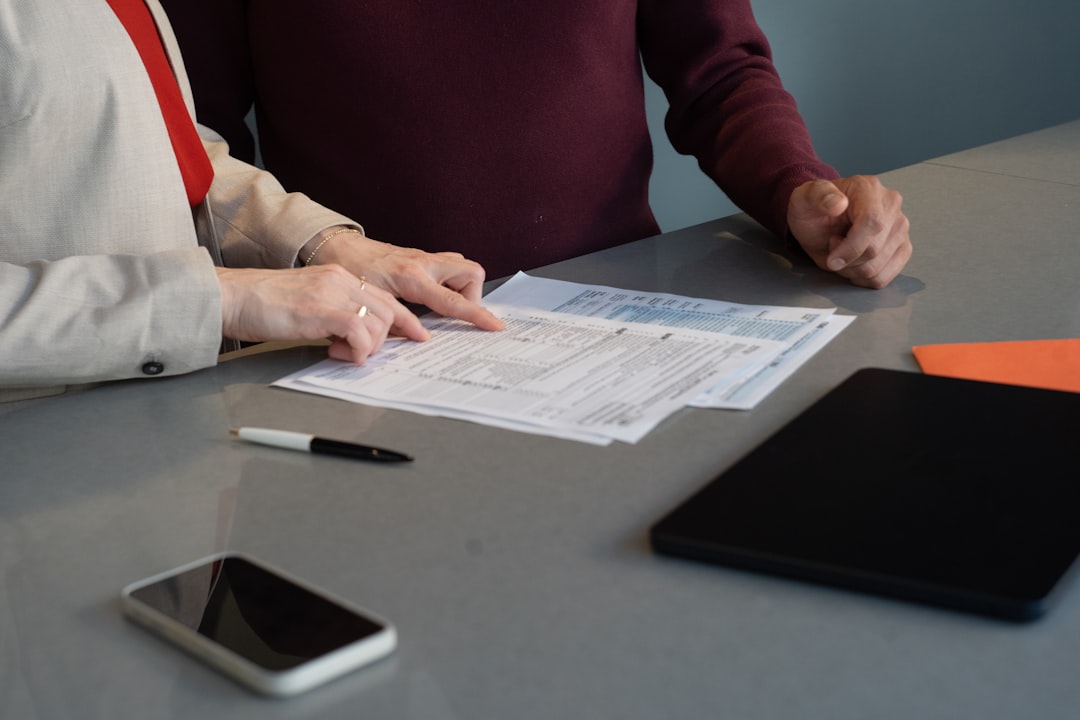 Two professionals reviewing paperwork at a conference table during a business meeting in San Francisco.